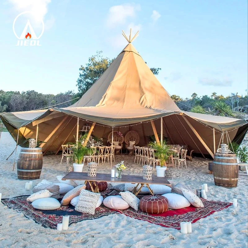 Tipi tent with open sides set up for an outdoor event on the beach