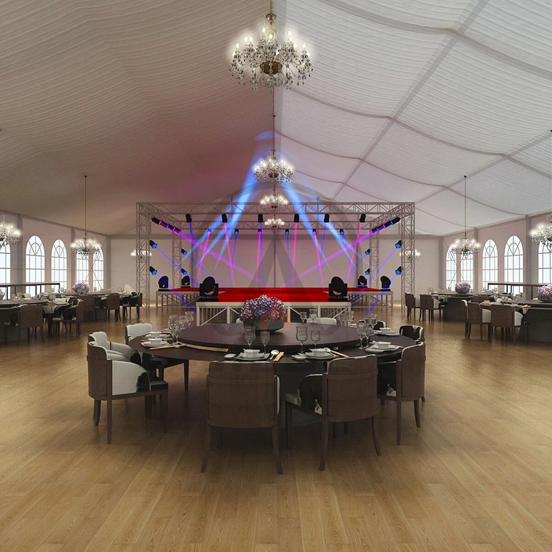 Elegantly decorated banquet hall with stage and chandeliers.